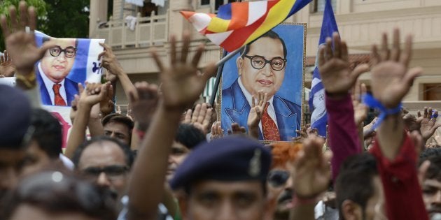 Photographs of Dr Ambedkar are raised as Indian members of the Dalit community take a pledge not to skin cattle. Thousands of members from the Dalit community took a pledge not to skin cattle to protest the recent beating of Dalit youths by so called Gau Rakshaks (Cow Protectors) in the Una region of Gujarat state, over a fortnight ago. / AFP / SAM PANTHAKY (Photo credit should read SAM PANTHAKY/AFP/Getty Images)