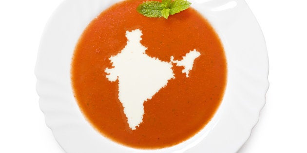 A top shot of an isolated plate with tomatosoup and cream in the shape of India (Asia). (series)