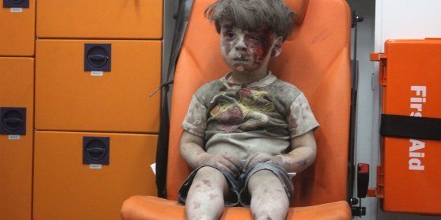 5-year-old Omran Daqneesh sits at the back of an ambulance after he got injured during an airstrike on August 17, 2016. (Photo by Mahmud Rslan/Anadolu Agency/Getty Images)