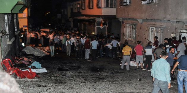 Bodies are covered as people gather at the explosion site on August 20, 2016 in Gaziantep, in a late night militant attack on a wedding party in southeastern Turkey. The governor of Gaziantep said 22 people are dead and 94 injured in the late night militant attack. / AFP / STR (Photo credit should read STR/AFP/Getty Images)