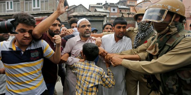 Indian policemen detain Masroor Abbas Ansari (C), leader of the All Parties Hurriyat Conference (APHC) group, during a protest in Srinagar against the recent killings in Kashmir.