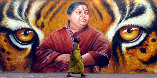 A woman walks in front of a portrait of Jayalalithaa in Chennai in 2009. REUTERS/Babu (INDIA)