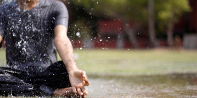 A young man doing yoga in rain. Image has a Low depth of field.