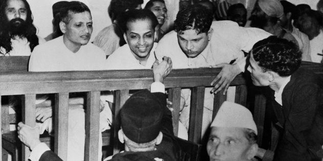 Some of the accused talk to their defense counsels before their trail for the assassination of Mahatma Gandhi. Left to right are Nathuram Vinayak Godse, Narayan Dattatraya Apte, Vishnu Rama Krishna and bearded man in the second row is M. Badge.