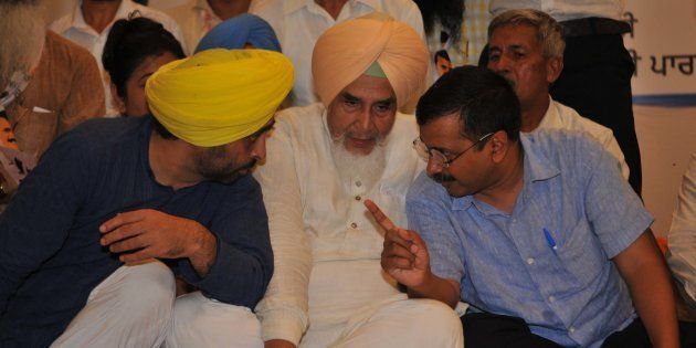 Delhi Chief Minister Arvind Kejriwal talking to Sangrur MP Bhagwant Mann and state party convener Sucha Singh Chhotepur during an AAP party rally.