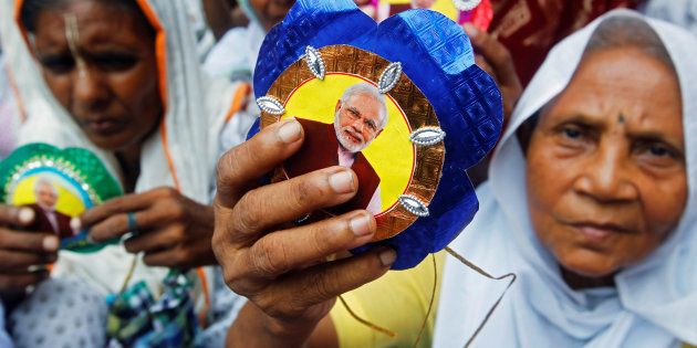 Widows, who have been abandoned by their families, show âRakhisâ or sacred threads with a picture of Indian Prime Minister Narendra Modi on them, as they wait to tie Rakhis to Hindu saints to celebrate Raksha Bandhan festival at a temple in Vrindavan in the northern state of Uttar Pradesh, India, August 17, 2016. REUTERS/Jitendra Prakash