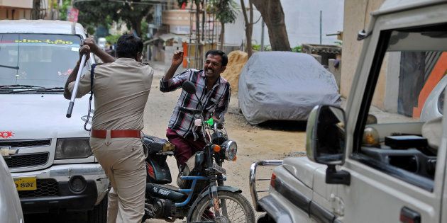 Police raises his baton at a man who defied a curfew in Bengaluru, following violent protests, India September 13, 2016.