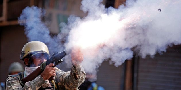 An Indian policeman fires a teargas shell towards demonstrators during a protest against the recent killings in Kashmir, in Srinagar September 13, 2016.