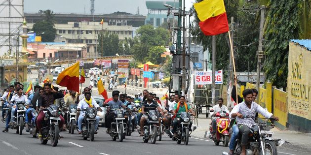Pro-Karnataka activists wave the Karnataka flag while they participate in a motorcycle rally during a statewide strike in Bangalore on September 9, 2016.