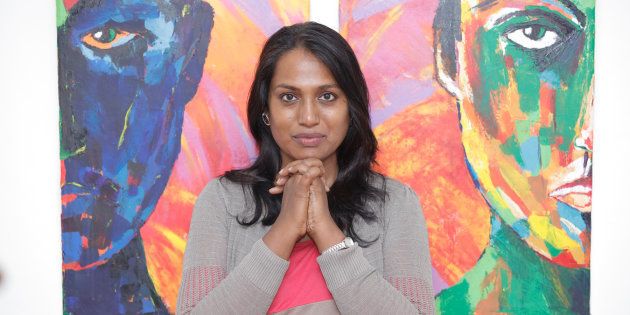 Transgender artivist Kalki Subramanium stands in front of one of her paintings