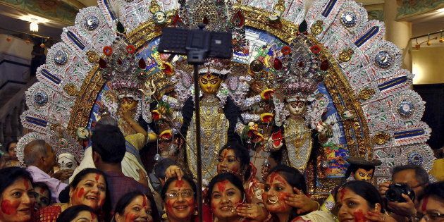 Hindu women use a selfie stick to take pictures after worshipping the idol of the Hindu goddess Durga on the last day of the Durga Puja festival in Kolkata, India, October 22, 2015. The Durga Puja festival is celebrated from October 19 to 22, which is the biggest religious event for Bengali Hindus. Hindus believe that the goddess Durga symbolises power and the triumph of good over evil. REUTERS/Rupak De Chowdhuri