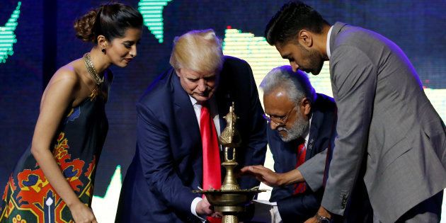Republican Hindu Coalition Chairman Shalli Kumar (2nd R) helps Republican presidential nominee Donald Trump (2nd L) light a ceremonial diya lamp before he speaks at a Bollywood-themed charity concert put on by the Republican Hindu Coalition in Edison, New Jersey, U.S. October 15, 2016. REUTERS/Jonathan Ernst