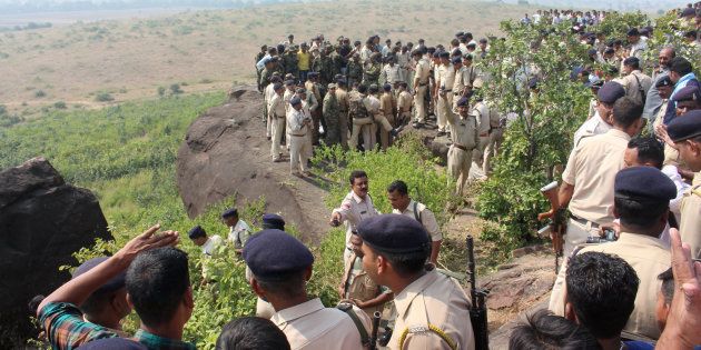 Indian police and bystanders gather at the site where eight SIMI activists, who escaped from Central Jail in Bhopal, were killed by Special Task Force police at the hillocks of Acharpura village, near the capital Bhopal on October 31, 2016. Indian police gunned down eight Islamists after they escaped from a high-security jail by slitting the throat of a prison guard and scaling the walls with knotted bedsheets.