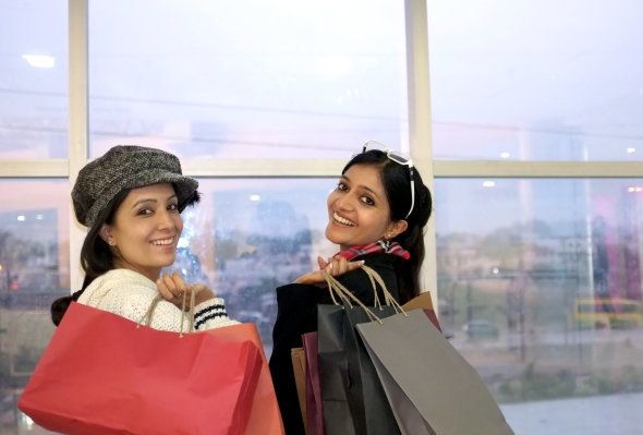 Group of happy smiling women shopping with colored bags.