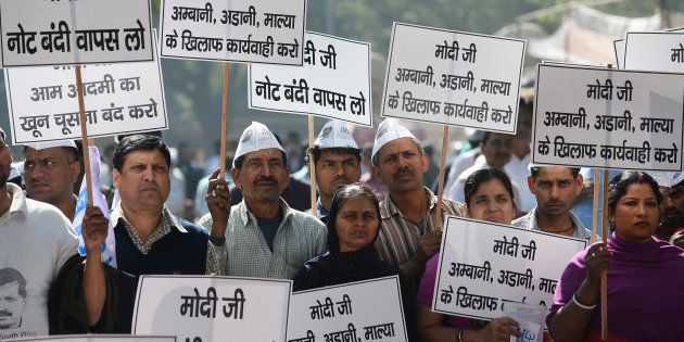 Activists and supporters of the Aam Aadmi Party (AAP) hold placards saying 'Modi ji is sucking the blood of the common man' during a protest against the demonetisation in New Delhi.