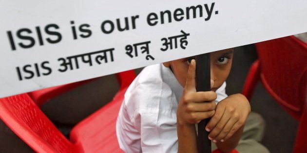 A Muslim boy looks on as he holds a placard at a rally organised by a Muslim charitable trust in Mumbai, India, November 26, 2015. REUTERS/Shailesh Andrade