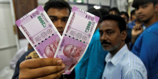 A man displays the new 2000 Indian rupee banknotes.