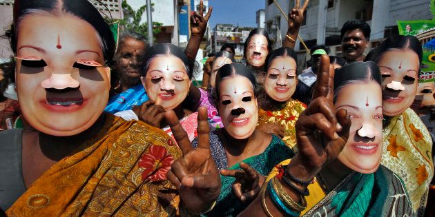 Supporters of J. Jayalalithaa wear masks as they gesture during an election campaign ahead of the general elections in Chennai, March 21, 2014.