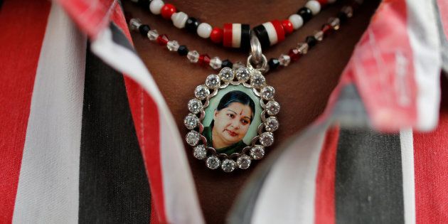 Jayalalithaa supporter wears a necklace with her picture as he attends a prayer ceremony at AIADMK office in Mumbai on 6 Dec.