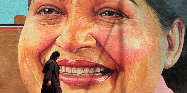 A woman walks past a portrait of J. Jayalalithaa, Chief Minister of the southern state of Tamil Nadu, in Chennai, India, March 13, 2012. REUTERS/Babu/File Photo