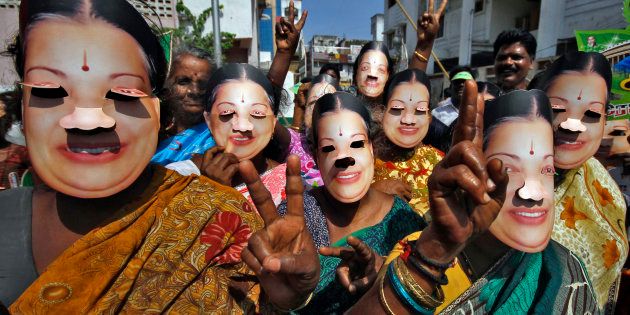 Supporters of J. Jayalalithaa, chief minister of India's Tamil Nadu state and chief of Anna Dravida Munetra Khazhgam (AIADMK), wear masks as they gesture during an election campaign ahead of the general elections in the southern Indian city of Chennai March 21, 2014. The politics of forming India's next government could come down to how many seats a 1960s matinee siren can wrest from a rival named Stalin in Tamil Nadu. Picture taken March 21, 2014. REUTERS/Babu (INDIA - Tags: POLITICS ELECTIONS)