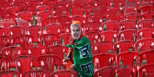 A supporter of Hindu nationalist Narendra Modi, prime ministerial candidate for India's main opposition Bharatiya Janata Party (BJP) and Gujarat's chief minister, wears a mask depicting Modi before the start of a rally in Hiranagar March 26, 2014.