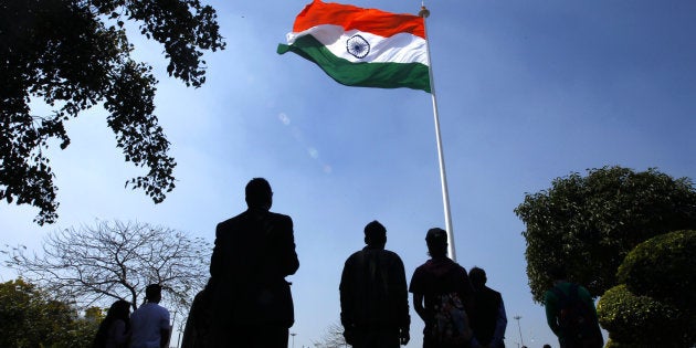 People stand for national anthem during the hoisting of the largest national flag, measuring 60 ft x 90ft, atop a 207 ft flag pole at Rajiv Chowk on 7 March 2014 in New Delhi, India. (Photo by Ajay Aggarwal/Hindustan Times via Getty Images)