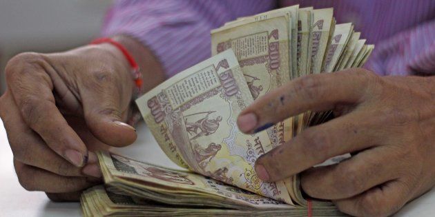 A man counts old 500 and 1000 notes inside the bank at Vashi, on November 21, 2016 in Mumbai, India.