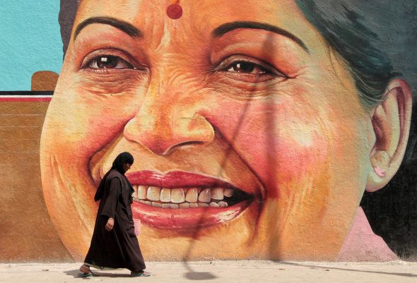 A woman walks past a portrait of J. Jayalalithaa, Chief Minister of the southern state of Tamil Nadu, in Chennai, India, March 13, 2012. REUTERS/Babu/File Photo TPX IMAGES OF THE DAY