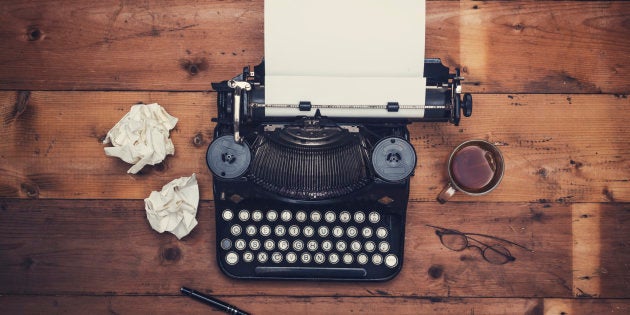 Top view thirties retro writers desk with typewriter on old wooden background table top.
