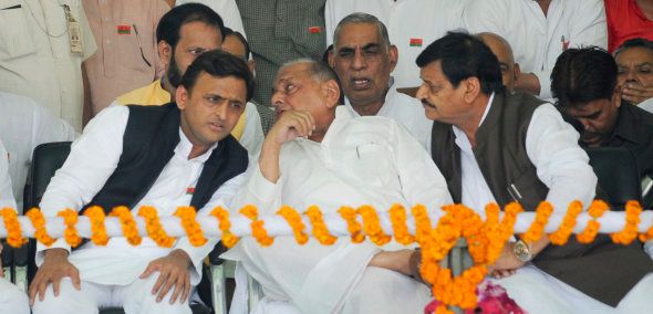 Uttar Pradesh Chief Minister Akhilesh Yadav talking to his father Mulayam Singh yadav while Shivpal Yadav looks on.