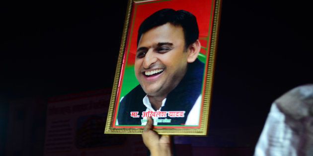 An Indian supporter of Uttar Pradesh's Chief Minister Akhilesh Yadav holds the photograph of Akhilesh Yadav as they protest against the eviction of Akhilesh Yadav from Samajwadi Party for 6 years.