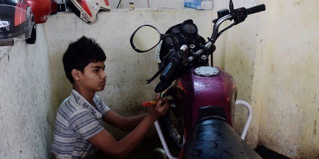 Bangladeshi worker Russel, and who says he will turn 14 next year, works in a garage in Dhaka on December 7, 2016. Bangladeshi child labourers who live in slums work for an average of 64 hours a week, many of them in textile factories making clothes for top world brands, a major study said December 7. The new report from the London-based Overseas Development Institute has found that 15 percent of Dhaka slum-dwellers aged between six and 14 did not go to school and worked full-time. / AFP / MUNIR