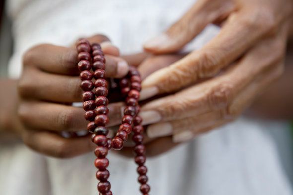 Close up of hands holding beads.
