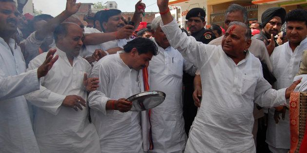 Samajwadi Party (SP) chief Mulayam Singh Yadav (R) waves to his supporters.