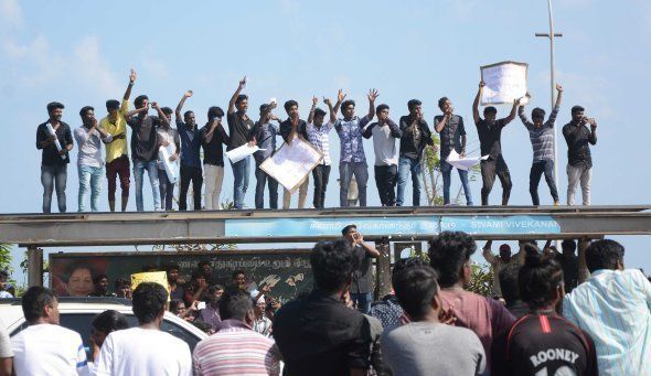 Indian students shout slogans from the top of a bus during a demonstration against the ban on the Jallikattu bull taming ritual at Marina Beach at Chennai on January 18 2017.