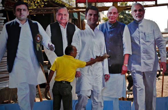 A worker cleans a cut-out of Rahul Gandhi (C) India's ruling Congress party Vice President, beside cut-outs of (L-R) Uttar Pradesh Chief Minister Akhilesh Yadav, Akhilesh's father and chief of Samajwadi Party Mulayam Singh Yadav, India's main opposition Bharatiya Janata Party President Rajnath Singh and prime minister Narendra Modi.
