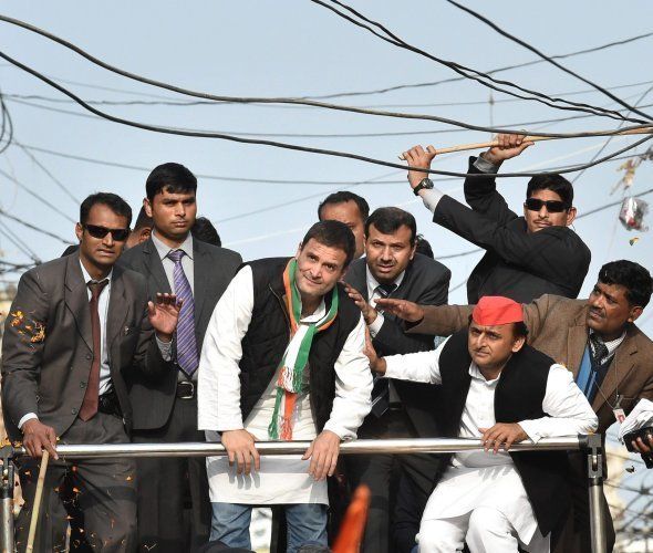 Lucknow : A security person pushing away elctric cables above Uttar Pradesh Chief Minister and Samajwadi Party President Akhilesh Yadav and Congress Vice President Rahul Gandhi during their road show in Lucknow on Sunday. PTI Photo by Nand Kumar (PTI1_29_2017_000223B)