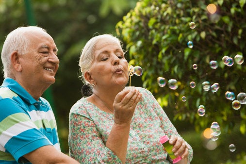 Senior couple blowing bubbles with wand