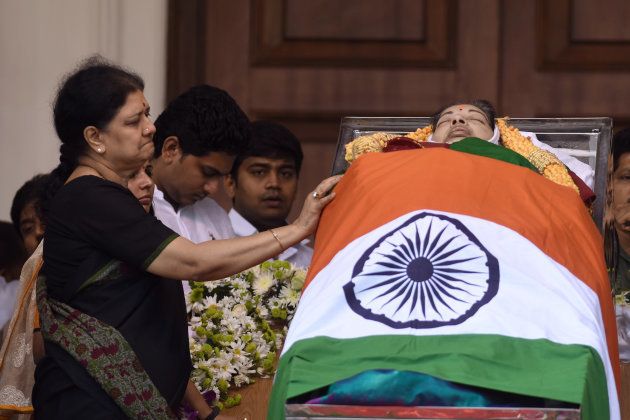 In this photograph taken on December 6, 2016, close aide, VK Sasikala (L) stands next to the mortal remains of former chief minister of Tamil Nadu state, Jayalalithaa Jayaram during her funeral in Chennai. The party of Jayalalithaa Jayaram, a powerful Indian political leader who died earlier this month, on December 29, 2016 picked one of her closest aides to succeed her, ending weeks of speculation. VK Sasikala was elected as the general secretary of southern Tamil Nadu state's ruling All India Anna Dravida Munnetra Kazhagam (AIADMK) after its chief, Jayalalithaa -- popularly known as 'Amma' or mother -- died aged 68 on December 5. / AFP / Arun SANKAR (Photo credit should read ARUN SANKAR/AFP/Getty Images)
