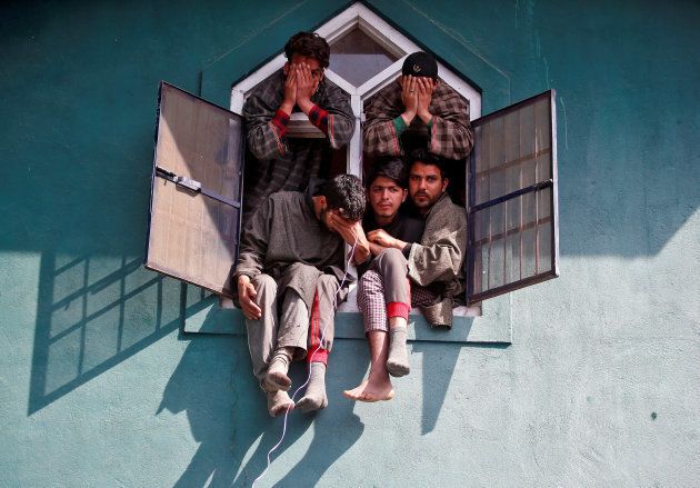 People react as they sit in a window of a mosque during the funeral of Tauseef Ahmad Wagay, a suspected militant, who according to local media was killed in a gun battle with Indian army on Tuesday in Chadoora, in Yaripora, in south Kashmir's Kulgam district, March 29, 2017. REUTERS/Danish Ismail TPX IMAGES OF THE DAY