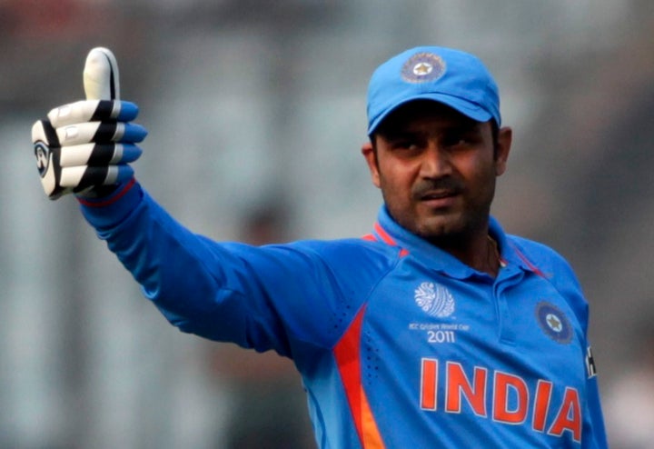 India's Virender Sehwag celebrates after he scored his century during the ICC Cricket World Cup group B match against Bangladesh in Dhaka February 19, 2011. REUTERS/Andrew Biraj (BANGLADESH - Tags: SPORT CRICKET)