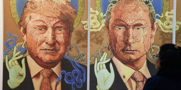 A visitor looks at a painting representing US President Donald Trump (L) and Russian President Vladimir Putin made by Nepalese artist Sunil Sidgel at the India Art Fair in New Delhi on January 2, 2017.