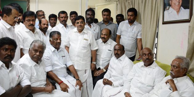 Chief Minister of the southern Indian state of Tamil Nadu O.Paneerselvam (bottom, 3L) is surrounded by supporters in front of a portrait of former state chief minister M.G Ramachandran, also known by his initials MGR, during a press conference at his home in Chennai on Febuary 8, 2017.A former video cassette seller with close ties to Tamil Nadu's late leader will become the next chief minister of the Indian state, capping a remarkable rise for the political novice. The ruling party in the southern state announced February 5 that VK Sasikala would become the next leader following the resignation of the acting chief minister. / AFP / STRINGER (Photo credit should read STRINGER/AFP/Getty Images)