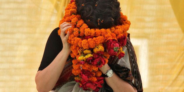 Priyanka Gandhi Vadra, daughter of India's ruling Congress party chief Sonia Gandhi, tries to remove her flower garlands as she campaigns for her mother during an election meeting at Rae Bareli in Uttar Pradesh April 22, 2014.