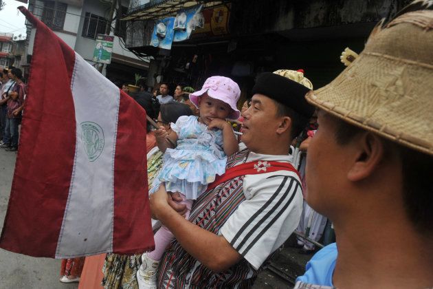 An ethnic Lepcha toddler holds a flag while waiting for the arrival of India's West Bengal state Chief Minister Mamata Banerjee for an event honouring the birthday of Nepali Poet Bhanu Bhakta in Kalimpong on July 13, 2012.