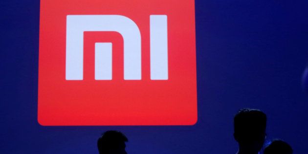Attendants are silhouetted in front of Xiaomi's logo at a venue for the launch ceremony of Xiaomi's new smart phone Mi Max in Beijing, May 10, 2016. REUTERS/Kim Kyung-Hoon/File Photo