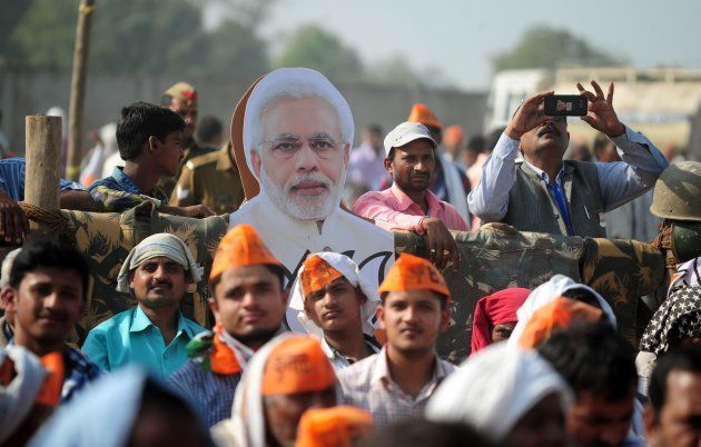Supporters of India's Bharatiya Janata Party (BJP) listen to BJP Leader and Indian Prime Minister Narendra Modi as he speaks during a state assembly election rally in the village of Andawa on the outskirts of Allahabad on February 20, 2017.