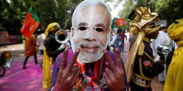 A supporter of India's Bharatiya Janata Party (BJP) celebrates after learning of the initial poll results outside the party headquarters in New Delhi, India, March 11, 2017. REUTERS/Adnan Abidi