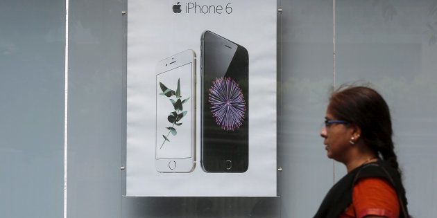 A pedestrian walks past an Apple iPhone 6 advertisement